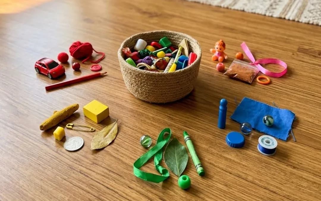 Toys, crayons, a bangle and a leaf sorted by colour on a wooden floor for a Navratri colour hunt
